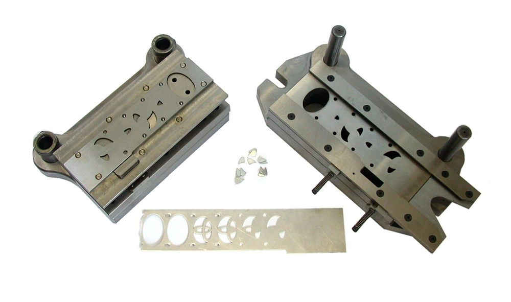 Matched upper punch and lower die with guide posts, showing a formed strip skeleton and separated parts after a press run